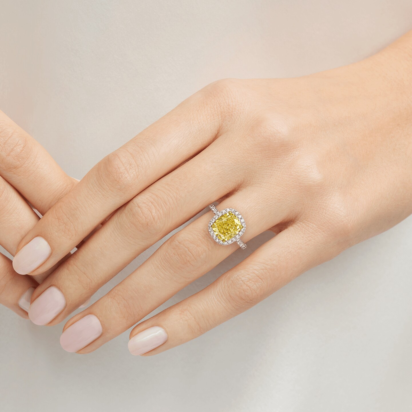 Bague diamant jaune taille coussin et micropavage présentée sur un modèle 