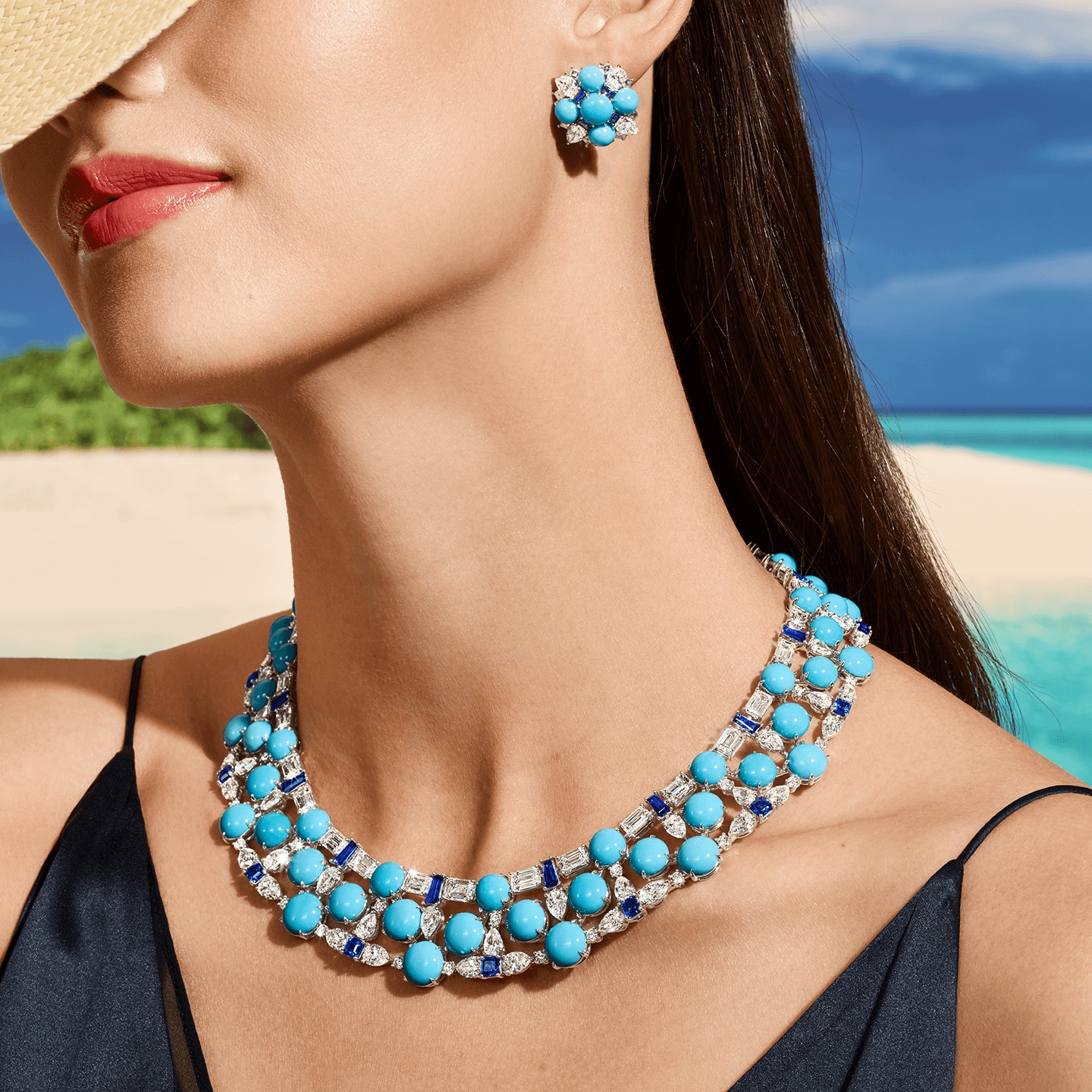 A female model in earrings and a necklace from Harry Winston's Fiji high jewelry suite.