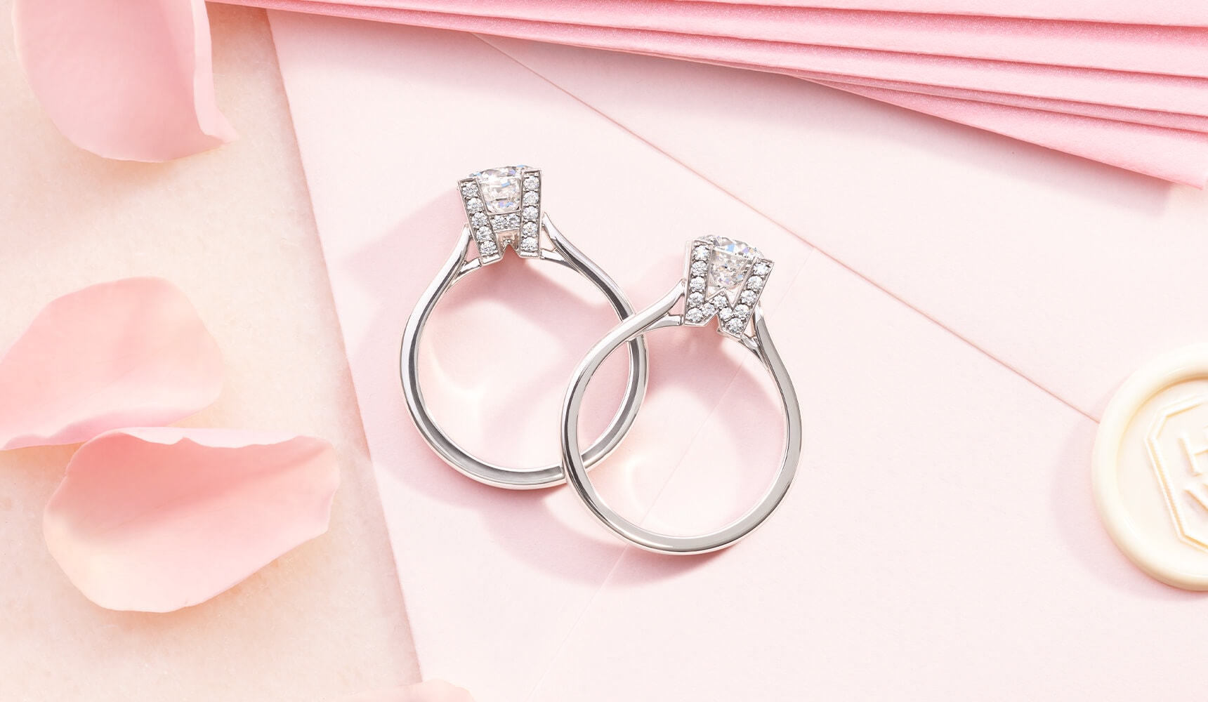 HW Logo Micropave Engagement Rings with pink envelopes and flower petals in the background