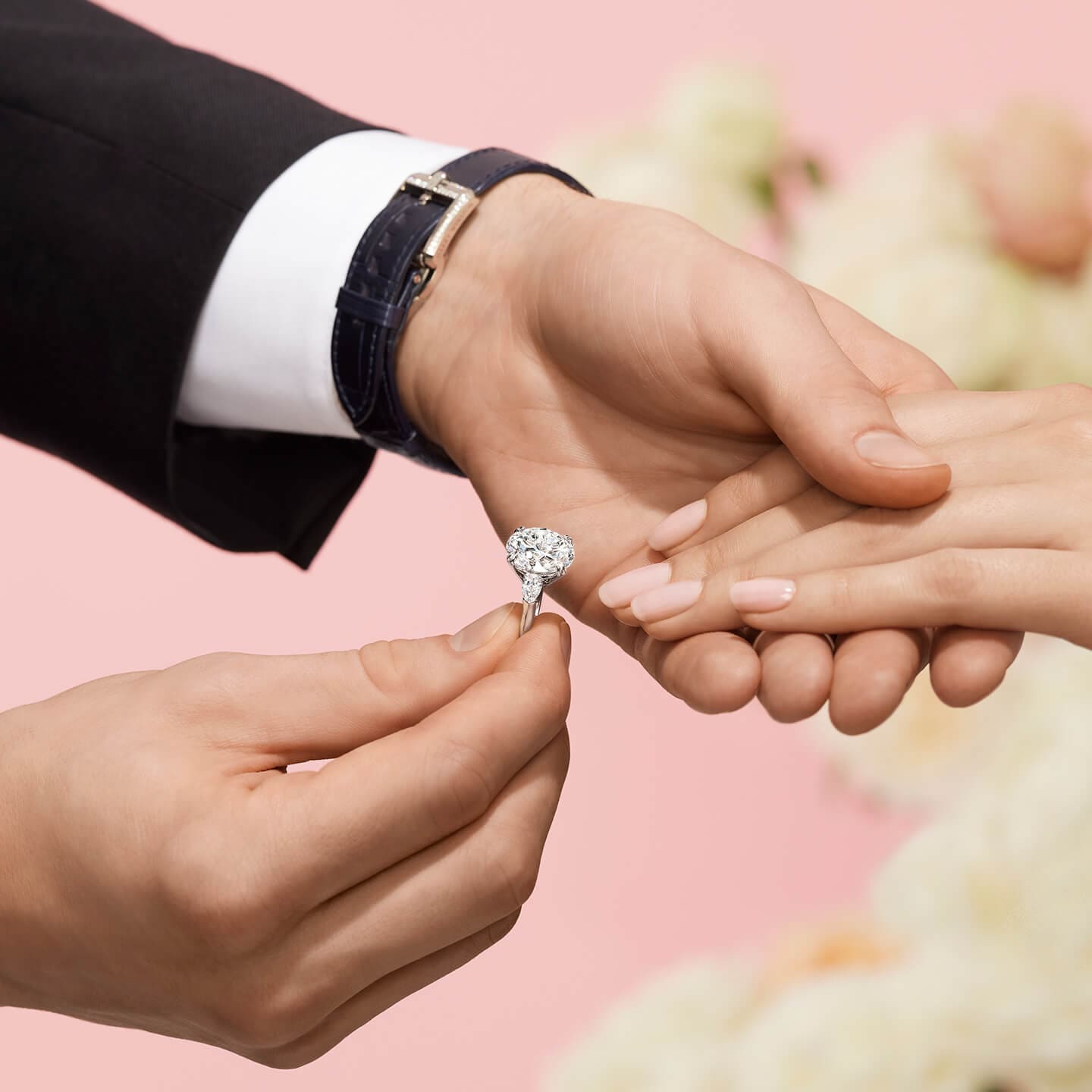 Male placing Diamond Engagement Ring on female hand