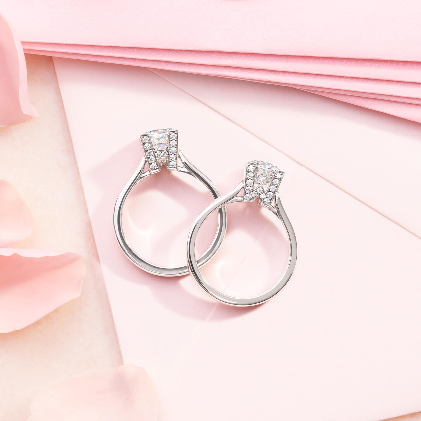 HW Logo Micropave Engagement Rings with pink envelopes and flower petals in the background