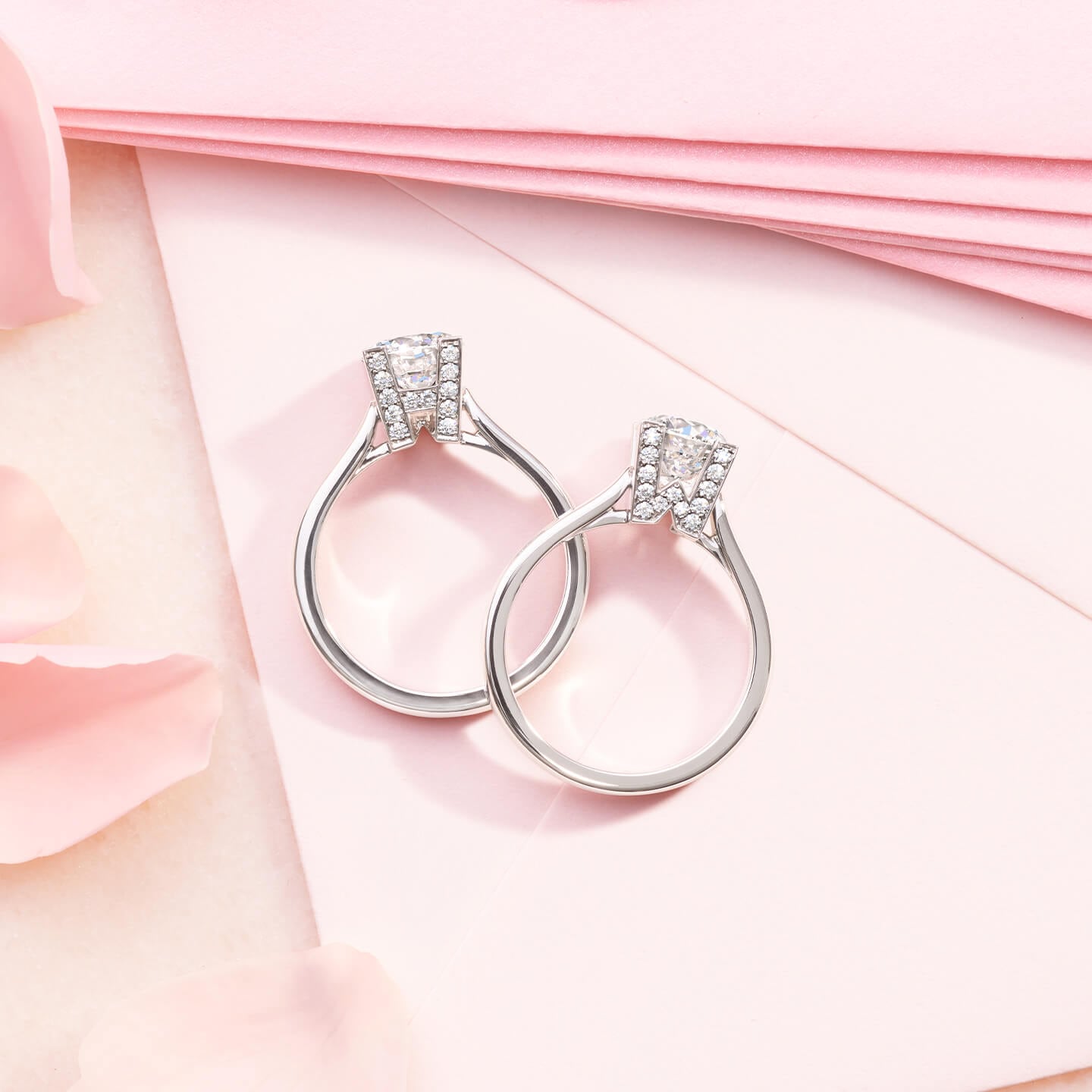 HW Logo Micropave Engagement Rings with pink envelopes and flower petals in the background