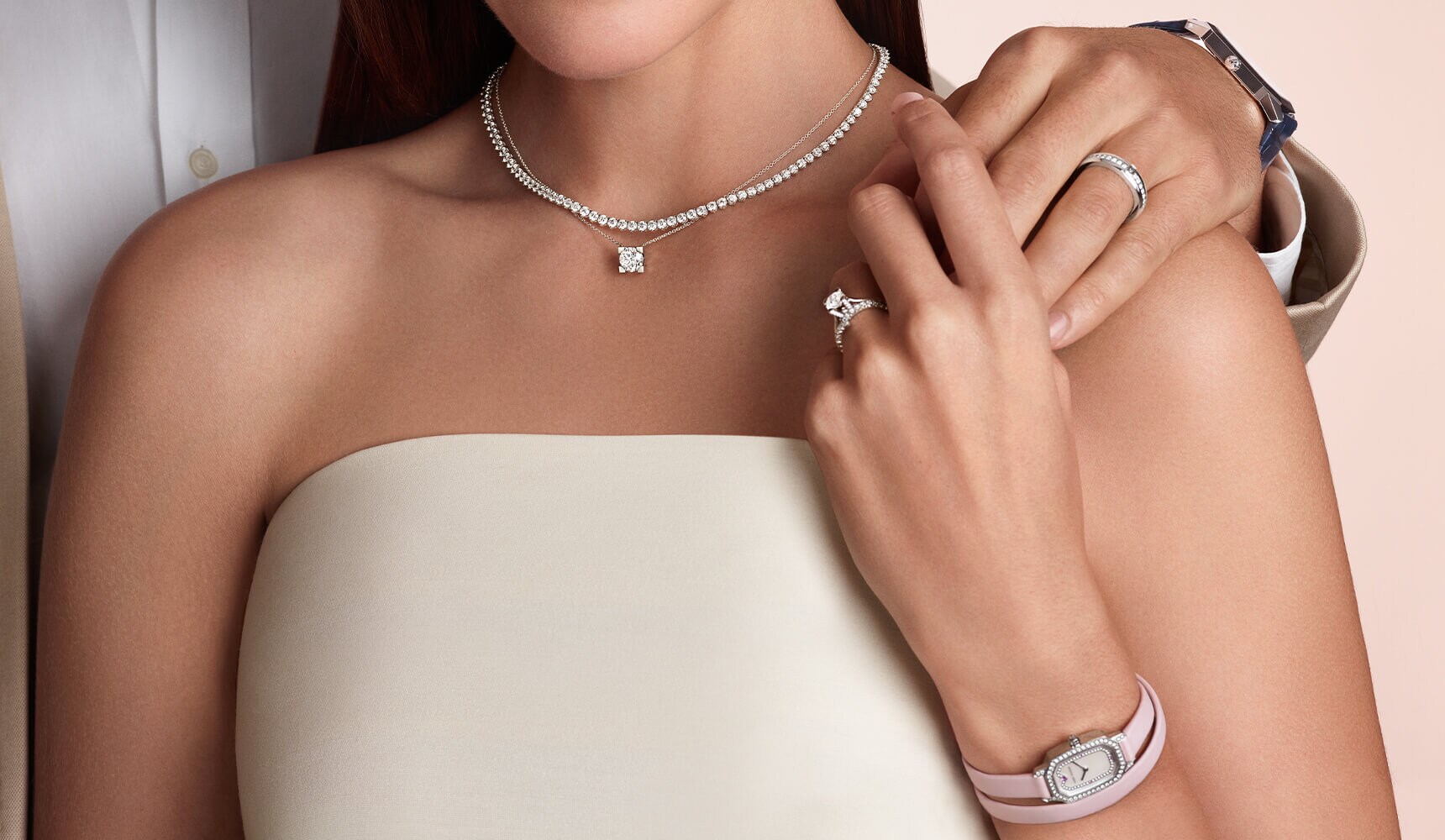 Bride wearing a Harry Winston engagement ring and groom's hand wearing a Harry Winston watch.
